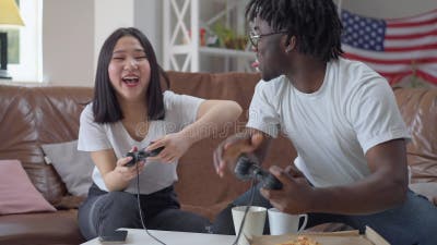 Happy Afro American girlfriend and boyfriend play games on