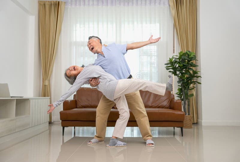 cheerful asian senior couple having fun dancing in the living room,family lifestyle,relationship,romantic,togetherness