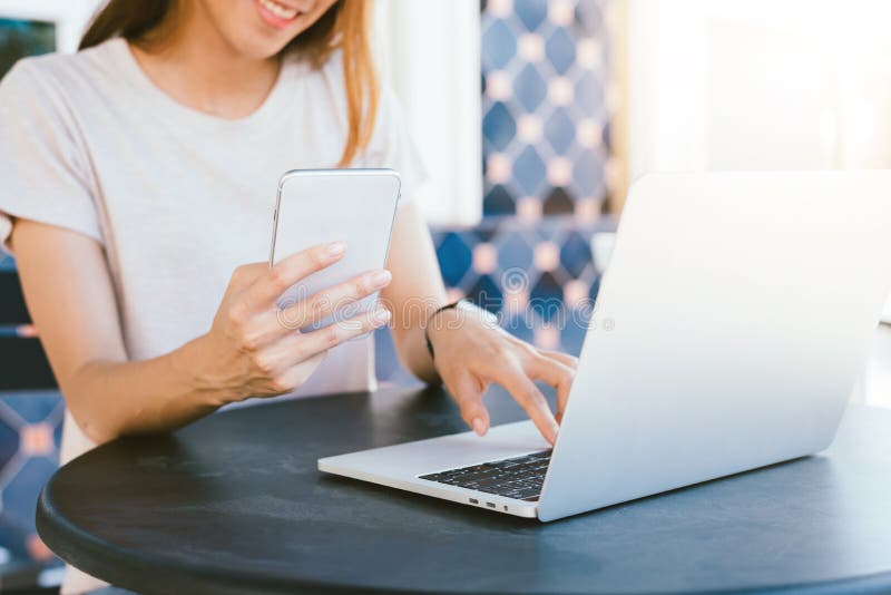 Cheerful asian young woman sitting in cafe drinking coffee and using smartphone for talking, reading and texting. stock images Cheerful asian young woman sitting in cafe drinking coffee and using smartphone for talking, reading and texting. stock images