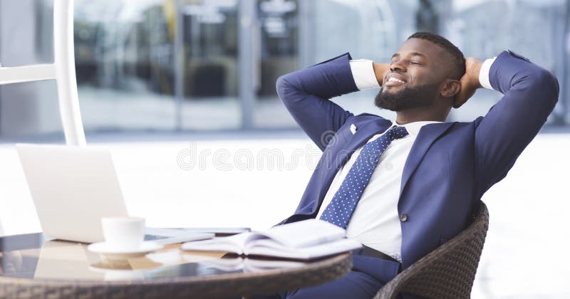 Cheerful black businessman relaxing in outdoor cafe, panorama stock images Cheerful black businessman relaxing in outdoor cafe, panorama stock images