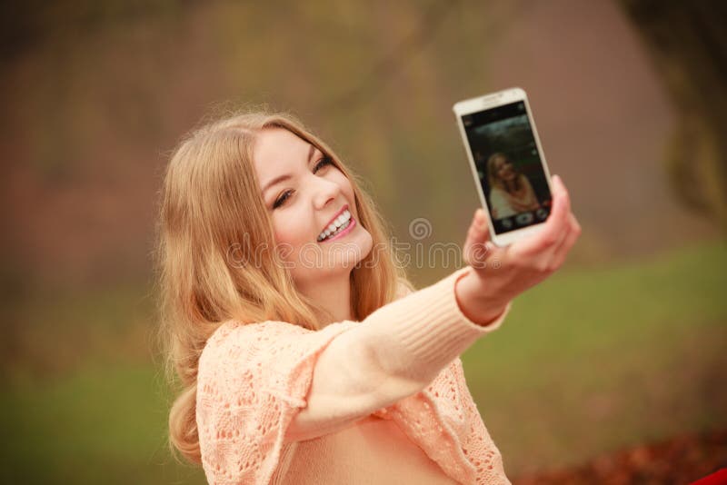 Cheerful blonde girl taking selfie.