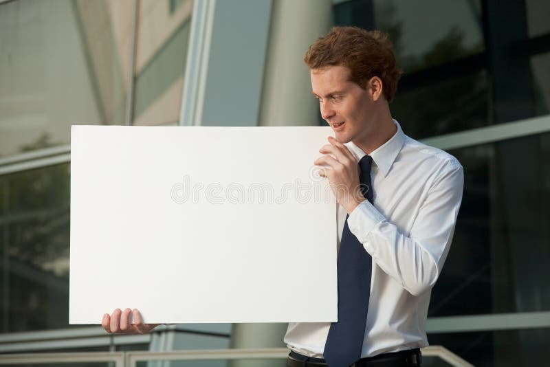 Cheerful Businessman Staring Blank Poster Sign stock photo Cheerful Businessman Staring Blank Poster Sign stock photo