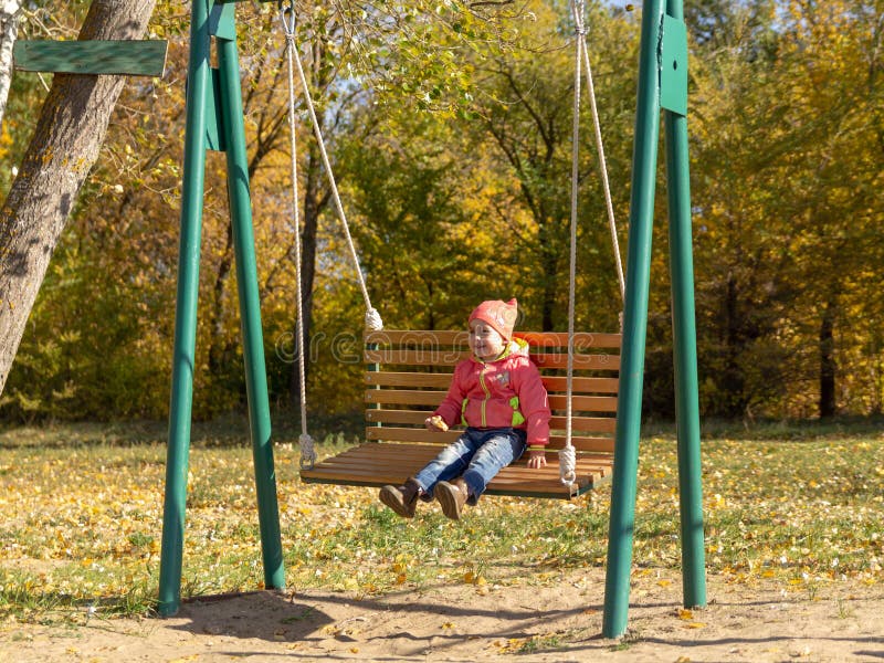 Child Swinging a Swing. Child Sitting on a Swing Stock Photo Image of