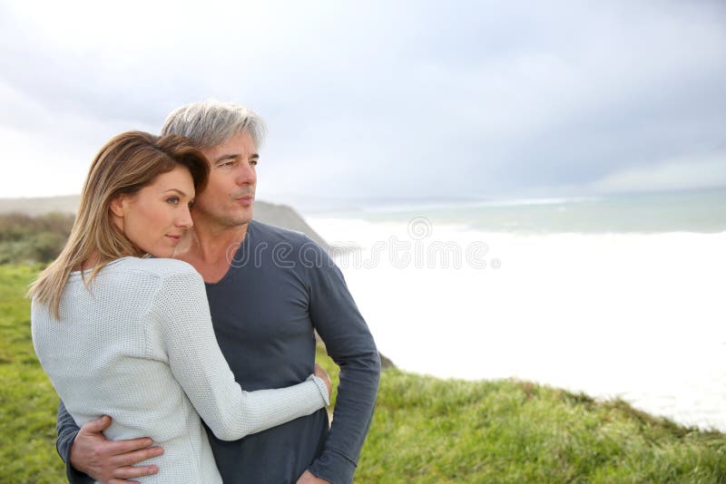 Cheerful couple standing by ocean stock photos Cheerful couple standing by ocean stock photos