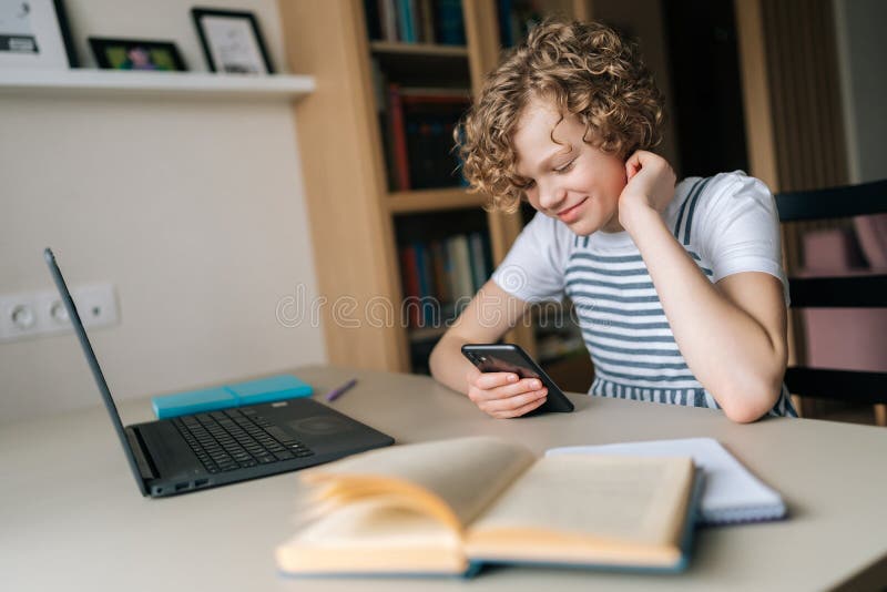 Cheerful curly preteen girl holding and using smartphone, browsing social network apps, surfing internet and scrolling royalty free stock photos