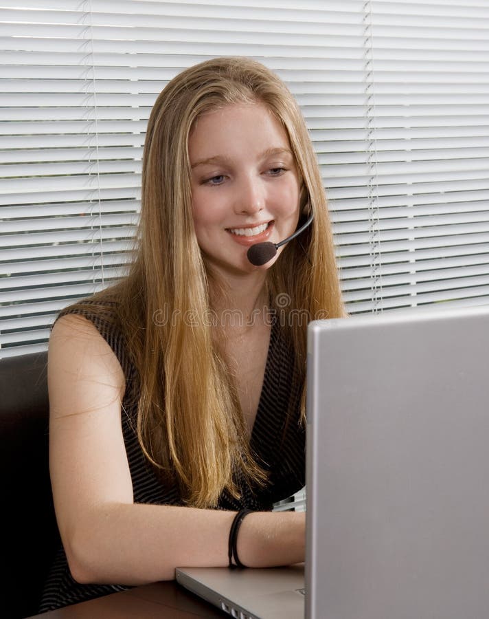 Pretty customer service representative at her computer monitor wearing headset. Pretty customer service representative at her computer monitor wearing headset.