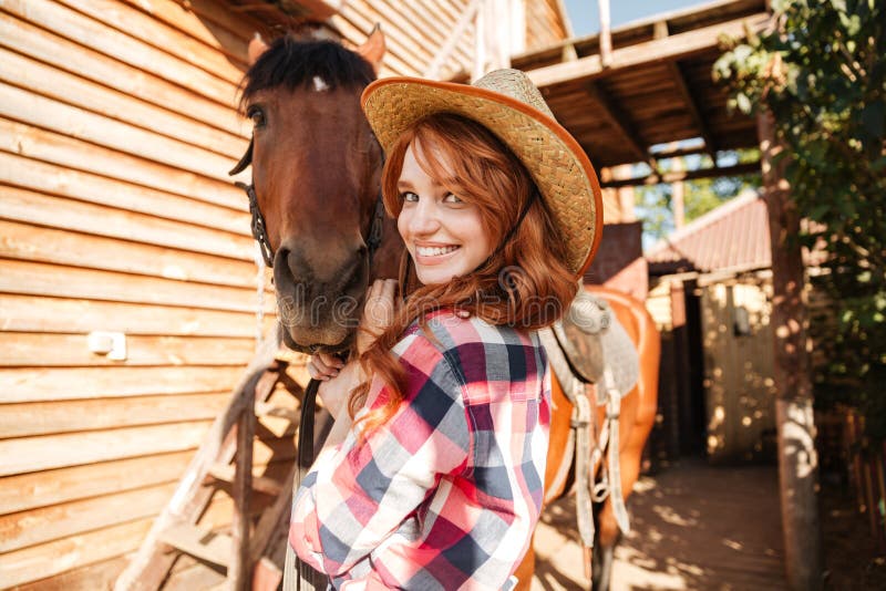 Cheerful cute young woman cowgirl in hat with horse stock images Cheerful cute young woman cowgirl in hat with horse stock images
