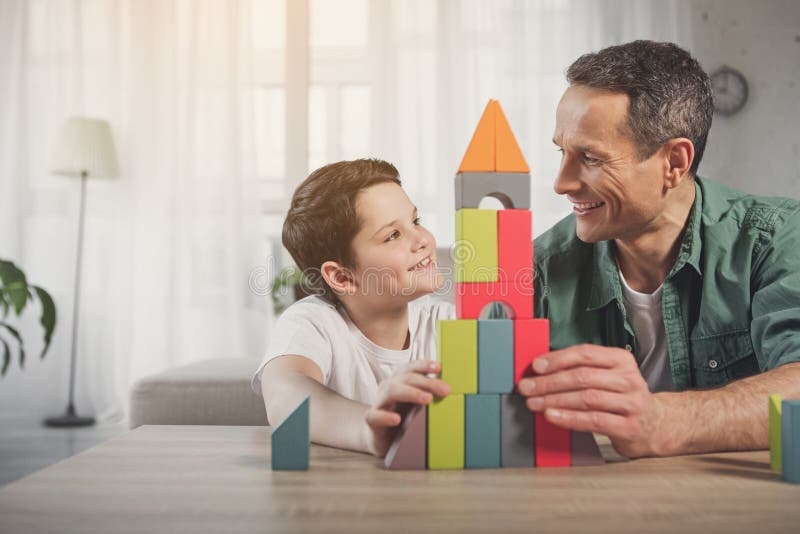 Cheerful dad and kid enjoying game at home stock photo Cheerful dad and kid enjoying game at home stock photo