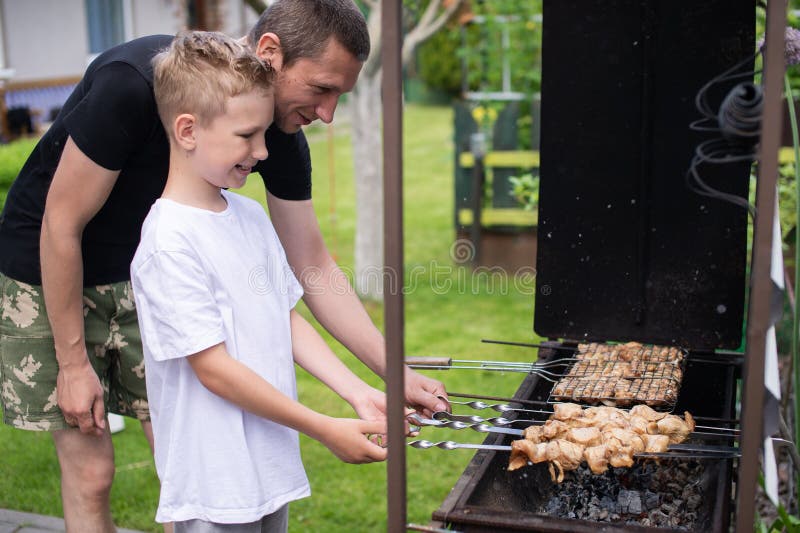 Cheerful Dad and Son Roast Meat on the Grill Stock Image Image of