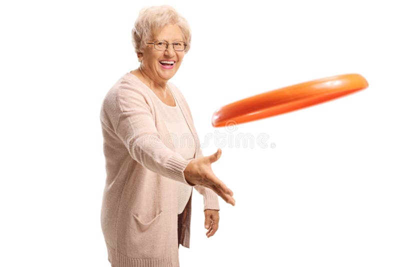 Cheerful elderly woman throwing a plastic disc