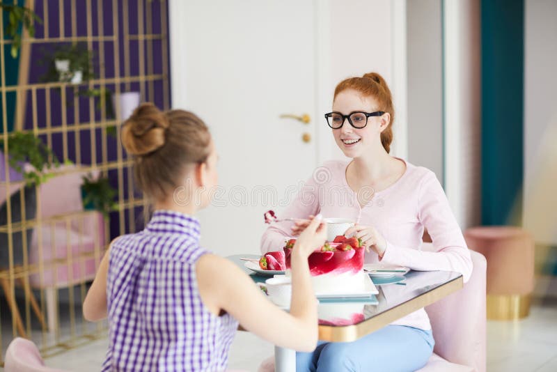 Female friends with cake in cafe royalty free stock photo Female friends with cake in cafe royalty free stock photo