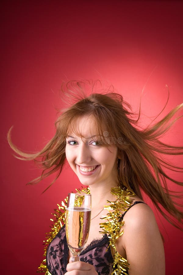 Cheerful girl with flying hair and champagne glass