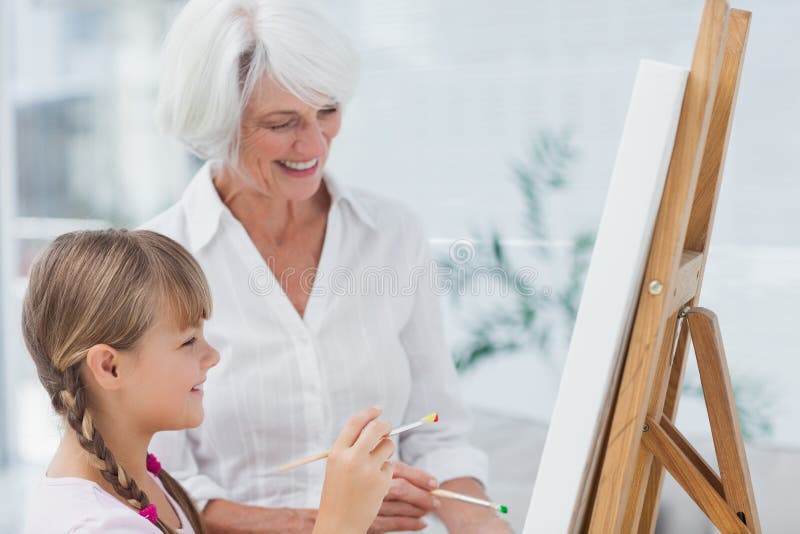 Cheerful grandmother and granddaughter painting together stock photography Cheerful grandmother and granddaughter painting together stock photography
