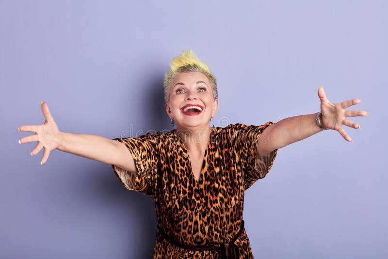 Happy mature stylish cool woman greeting guests, going to embrace friends. Cheerful happy mature stylish cool woman greeting guests, going to embrace friends stock photo Happy mature stylish cool woman greeting guests, going to embrace friends. Cheerful happy mature stylish cool woman greeting guests, going to embrace friends stock photo