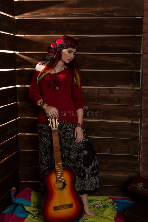 Cheerful Hippie Boho Redhead Woman Standing With Guitar On A Wooden