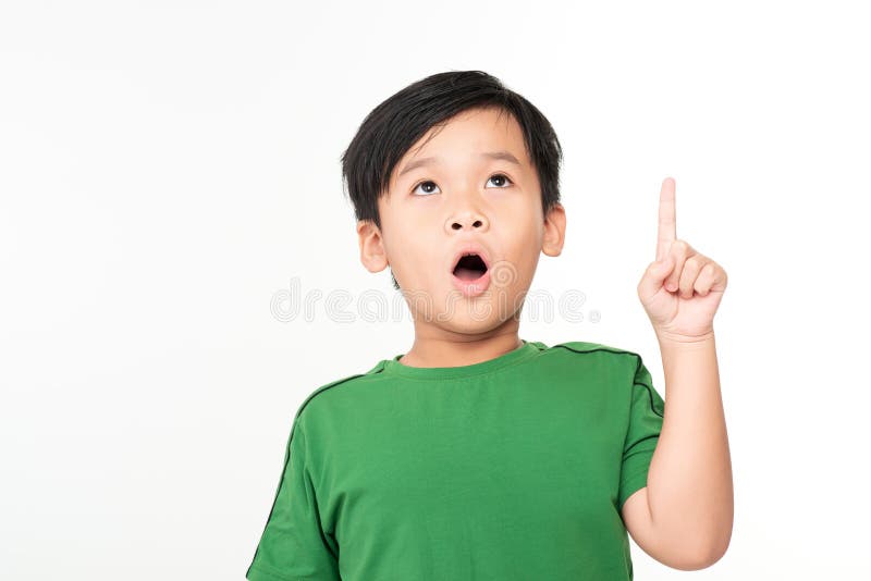 Cheerful little boy pointing up over white background