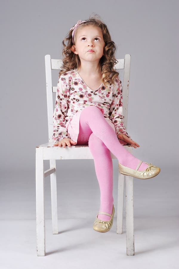 Sweet Little Girl Sitting on the White Chair, Looking Away Stock Image ...
