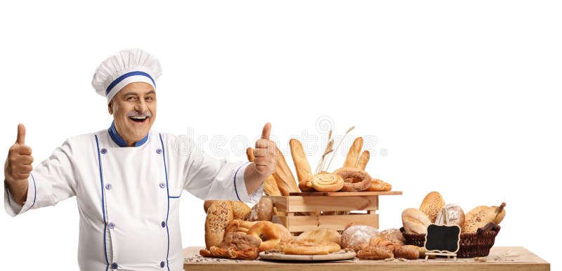 Cheerful male chef with a variety of bread loaves smiling and showing thumbs up