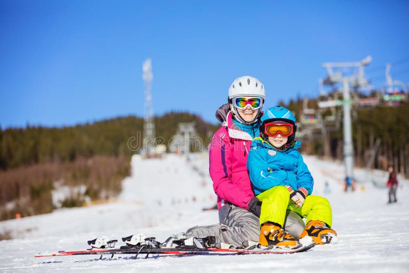 Cheerful mother and son resting on ski slope