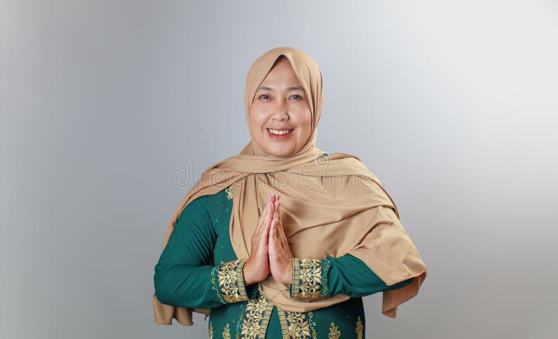 Cheerful Muslim Woman in Elegant Green Dress Giving Greeting Gesture royaltyfri bild