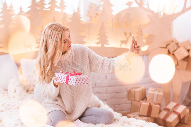 Cheerful nice woman taking a selfie with her present stock photography Cheerful nice woman taking a selfie with her present stock photography