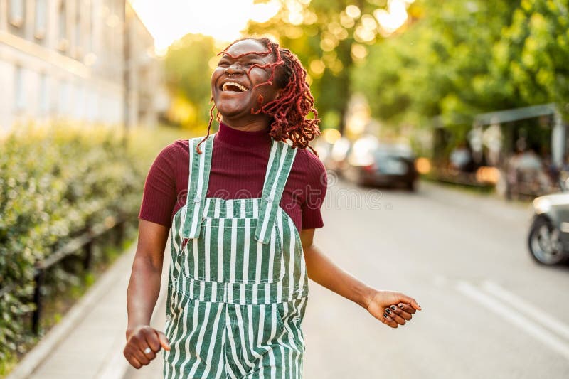 Cheerful non-binary person dancing on the street in the city royalty free stock photography