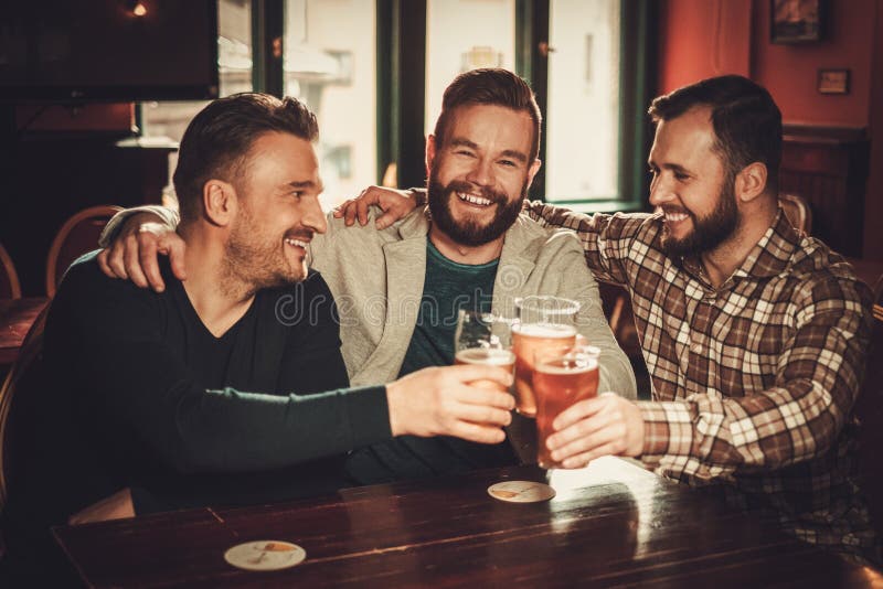 Cheerful old friends having fun and drinking draft beer in pub. Cheerful old friends having fun and drinking draft beer in pub stock photography Cheerful old friends having fun and drinking draft beer in pub. Cheerful old friends having fun and drinking draft beer in pub stock photography