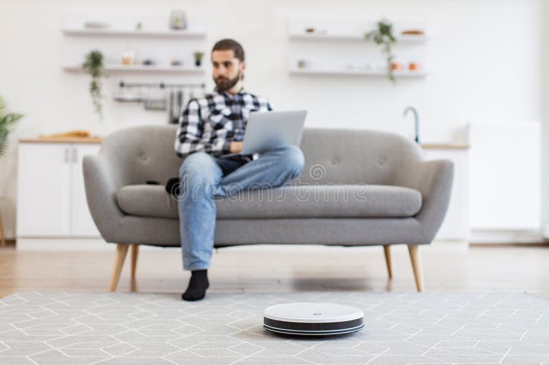 Cheerful owner programming home gadget via remote control while focusing on work royalty free stock photography