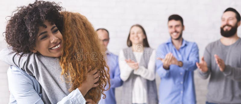 Cheerful people hugging during group therapy session royalty free stock photos