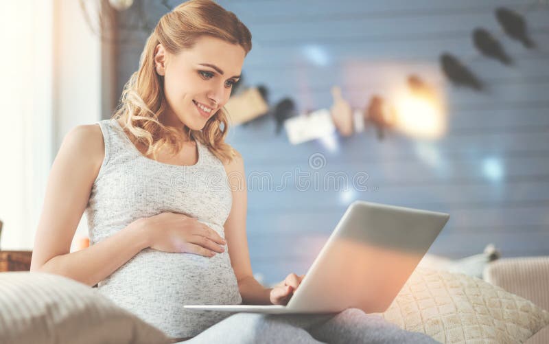 Cheerful pregnant woman using laptop royalty free stock images Cheerful pregnant woman using laptop royalty free stock images