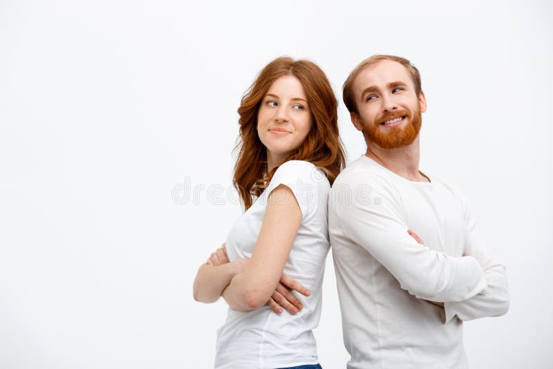 Cheerful redhead girl with boy dressed in white shirt standing. Cheerful redhead girl with boy dressed in white t-shirt standing over white background royalty free stock images Cheerful redhead girl with boy dressed in white shirt standing. Cheerful redhead girl with boy dressed in white t-shirt standing over white background royalty free stock images
