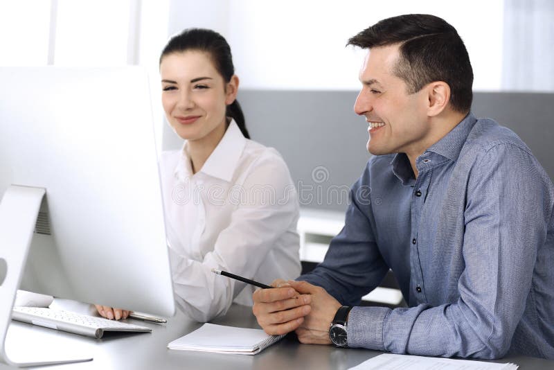 Cheerful smiling businessman and woman working with computer in modern office. Headshot at meeting or workplace royalty free stock images