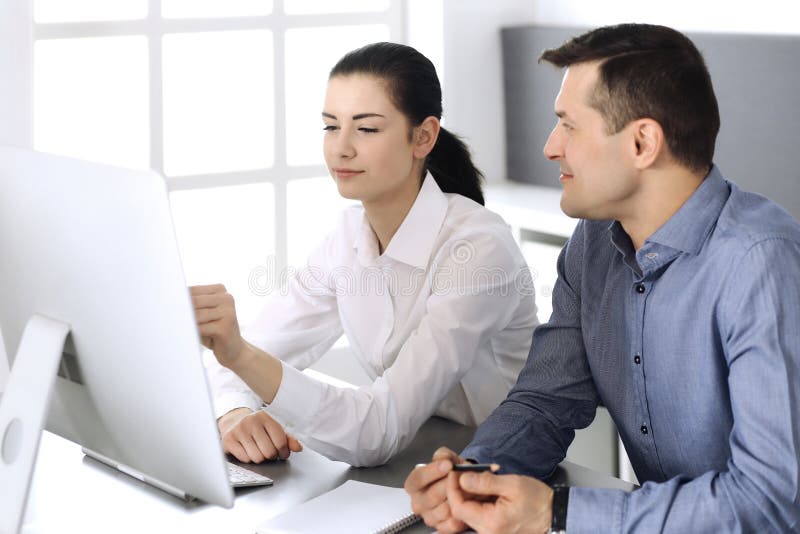 Cheerful smiling businessman and woman working with computer in modern office. Headshot at meeting or workplace stock photo