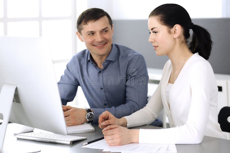 Cheerful smiling businessman and woman working with computer in modern office. Headshot at meeting or workplace stock images