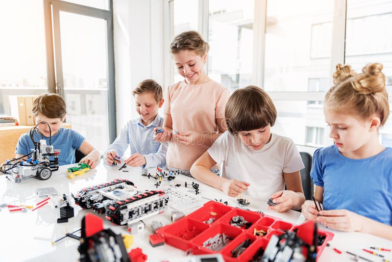 Cheerful smiling children constructing lego stock photos