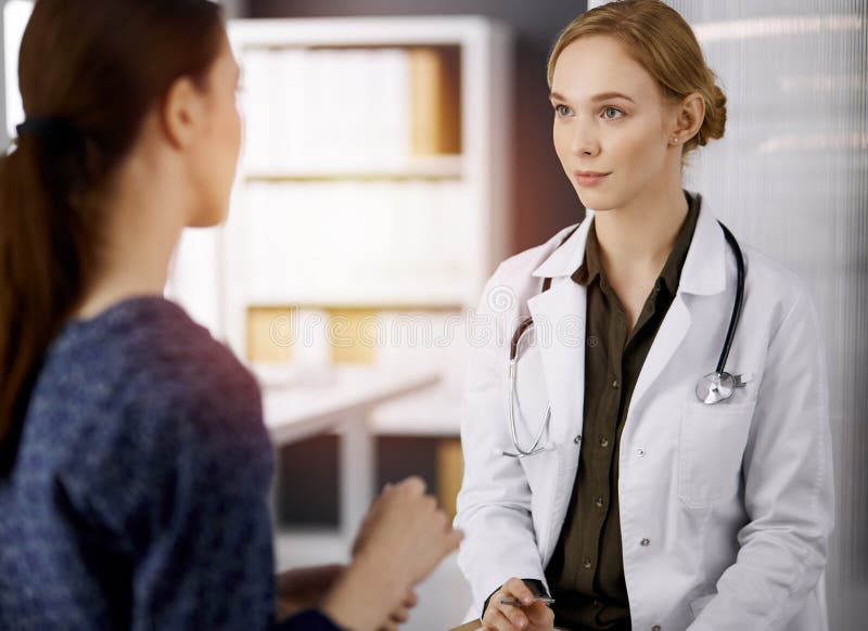 Cheerful Smiling Female Doctor And Patient Woman Discussing Current Health Examination While