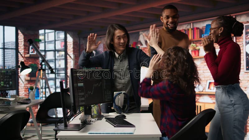 Startup team cheering after seeing company stocks raising, doing high five stock video