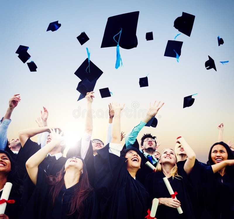 Cheerful students throwing graduation caps in the Air.