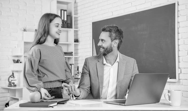 Cheerful teen kid with man teacher in classroom. education stock images