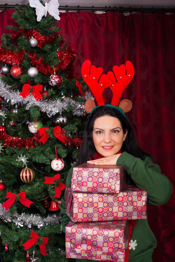 Cheerful woman holding stack of presents