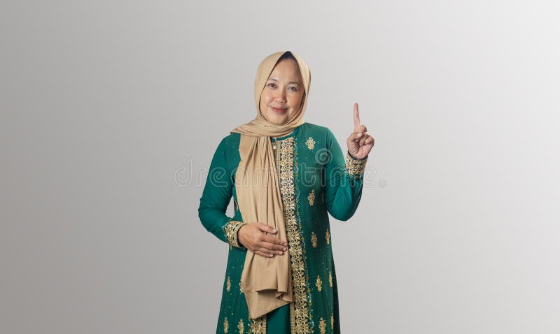 Cheerful Woman i traditionell grön pressmarkering uppåt med ett fingrar arkivbild