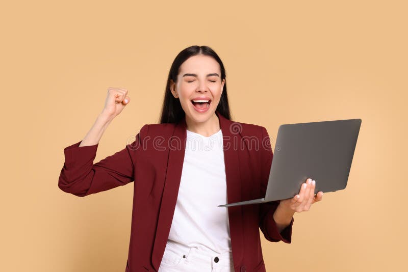 Cheerful woman with laptop on beige background royalty free stock photos