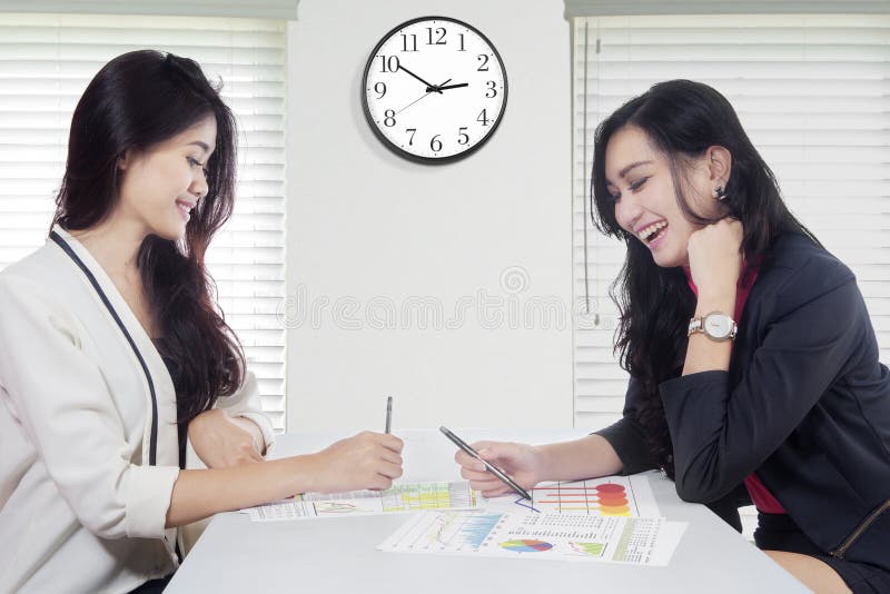 Cheerful workers with financial chart on desk royalty free stock image Cheerful workers with financial chart on desk royalty free stock image