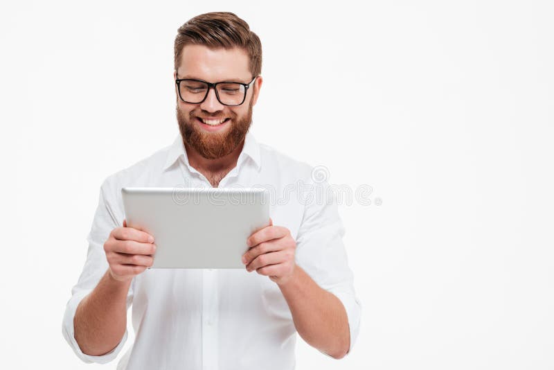 Cheerful young bearded man using tablet computer. stock images
