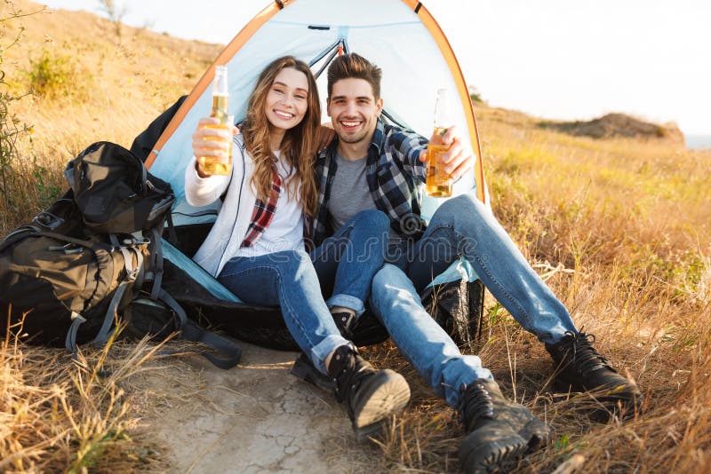 Cheerful young couple camping, sitting royalty free stock images Cheerful young couple camping, sitting royalty free stock images