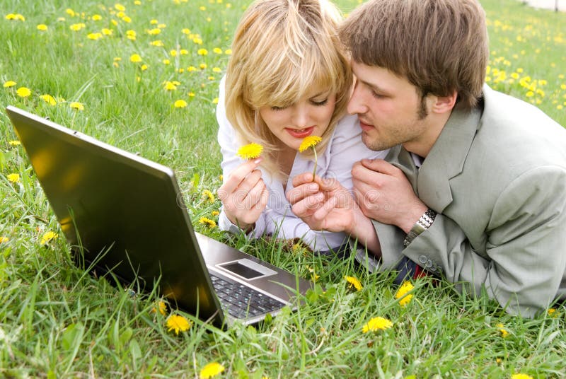 Cheerful young couple with laptop outdoors