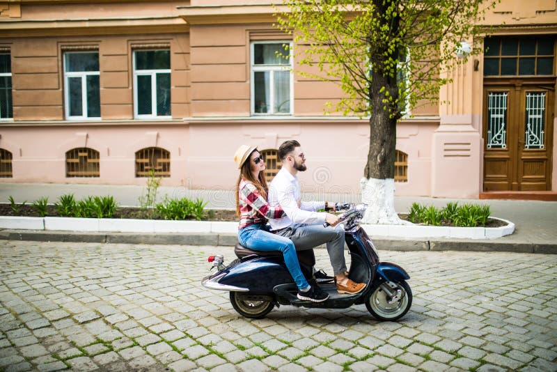 Cheerful Young Couple Riding a Scooter in Town Street with Fun Stock ...