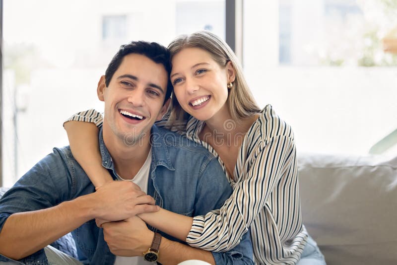 Cheerful young Hispanic husband and wife hugging with love royalty free stock images
