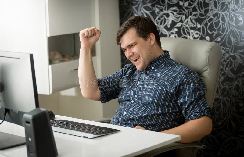 Portrait of cheerful young man celebrating success in job at office royalty free stock photo Portrait of cheerful young man celebrating success in job at office royalty free stock photo