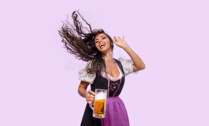 Cheerful young woman in Bavarian dress holding beer stock photo Cheerful young woman in Bavarian dress holding beer stock photo